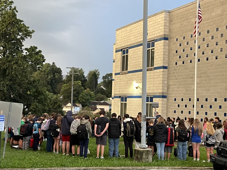 students gathered around flag pole