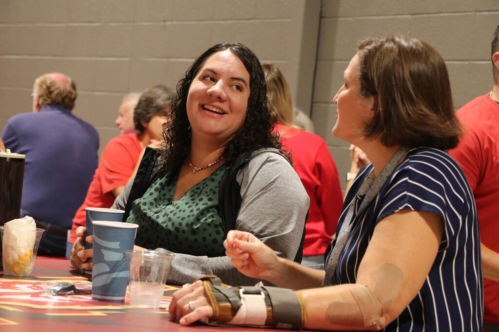 Two staff members laugh.