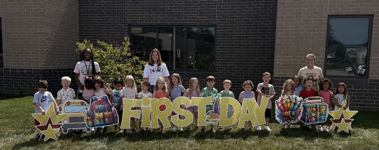 preschoolers in front of first day sign