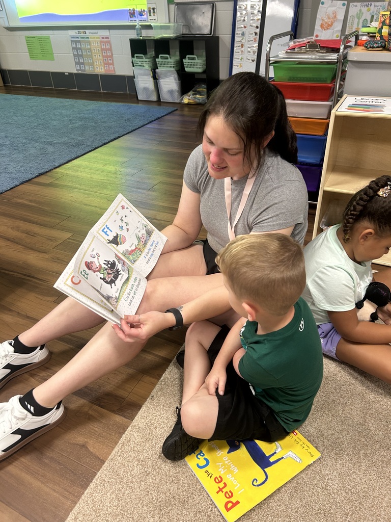 A student reads a book along with an associate.