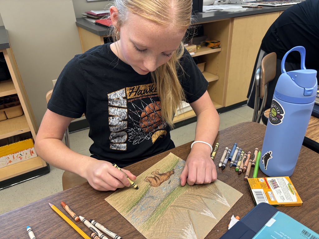 Student drawing a bear scene.