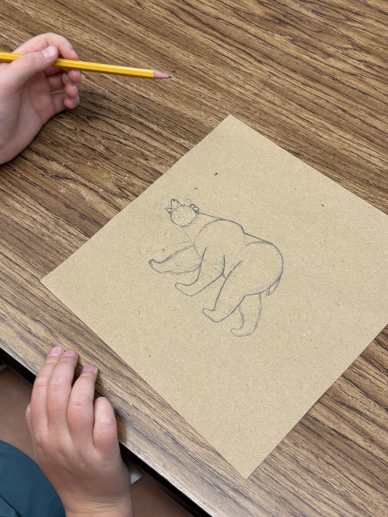 Student drawing a bear scene.