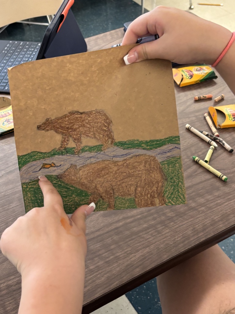 Student drawing a bear scene.