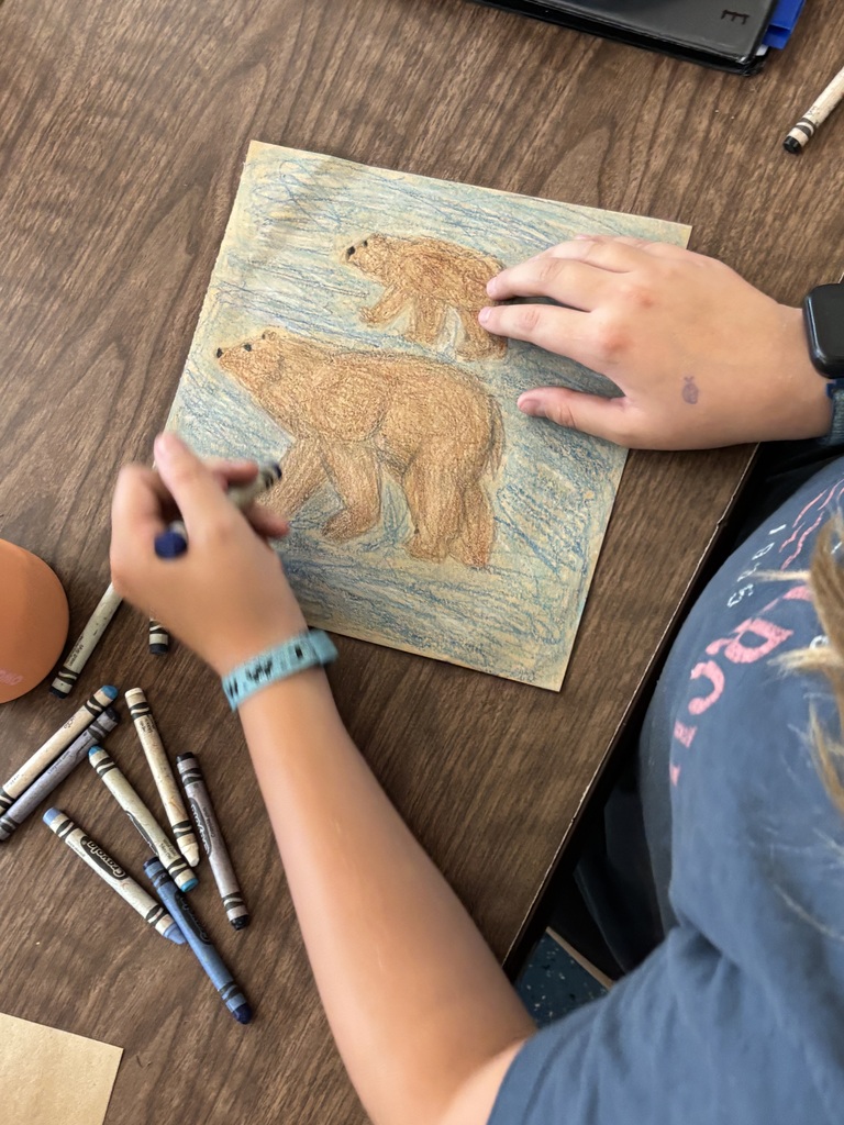 Student drawing a bear scene.