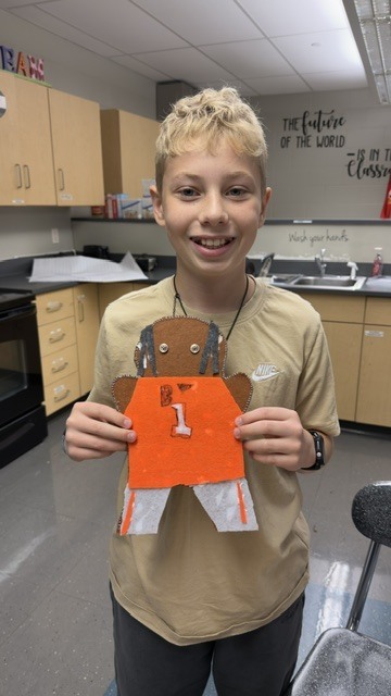 Student holding up sewing project.