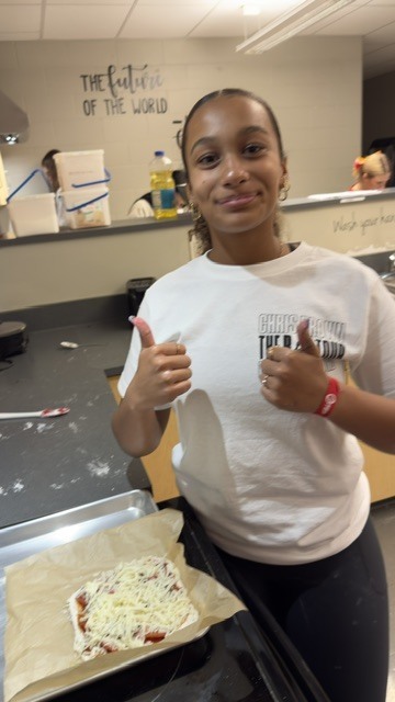 Student holding up sewing project.
