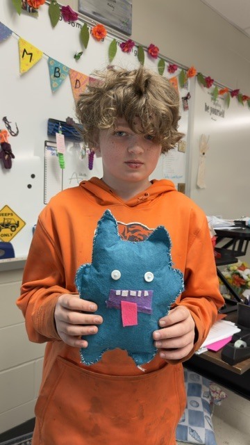 Student holding up sewing project.