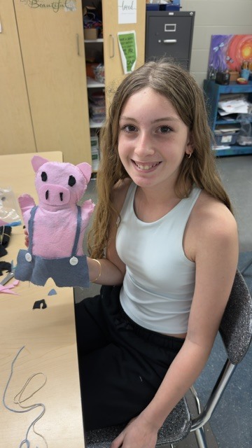 Student holding up sewing project.