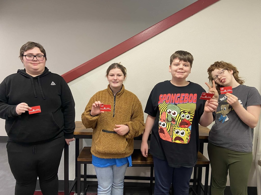 4 students holding up prizes.