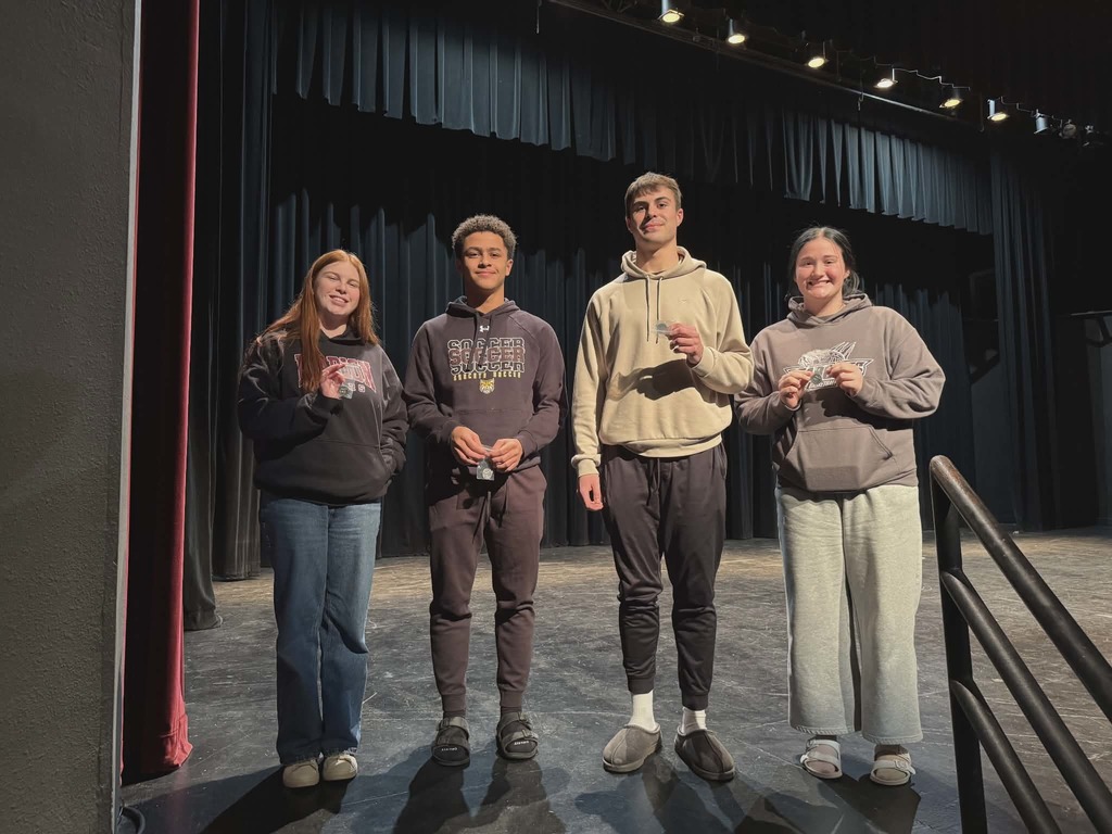 4 students holding up prizes.