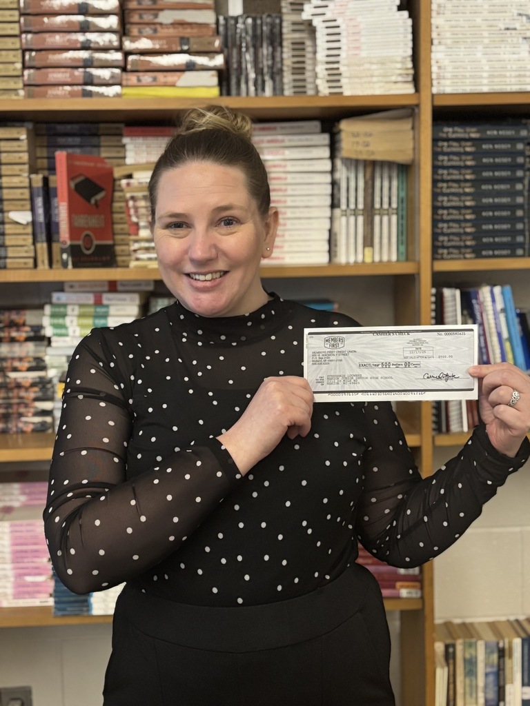Teacher with grant check.