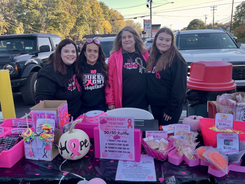Marlboro teachers and a student stand behind a fundraising table