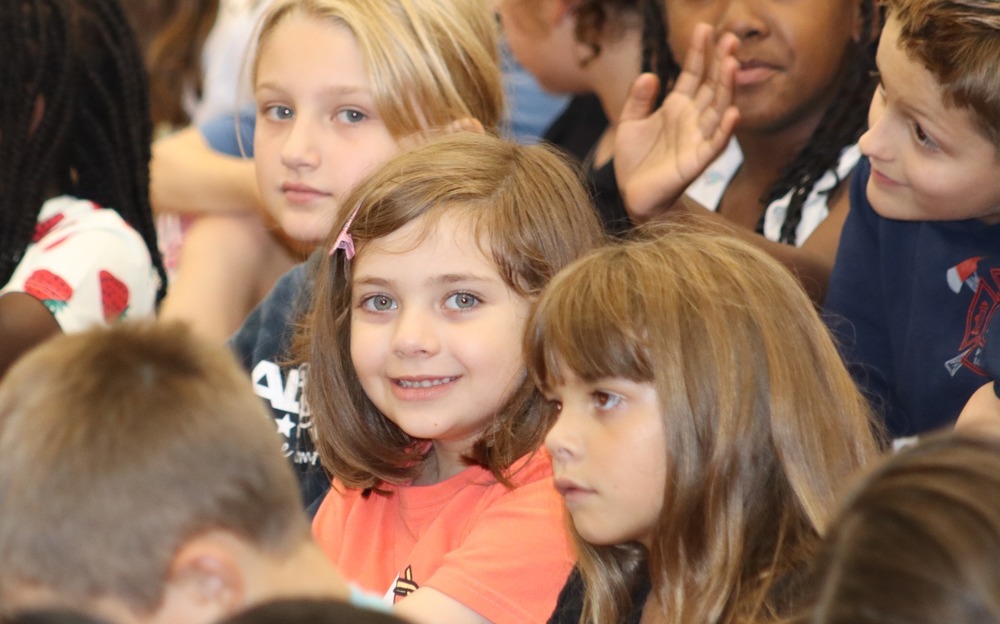 A girl in the audience smiles