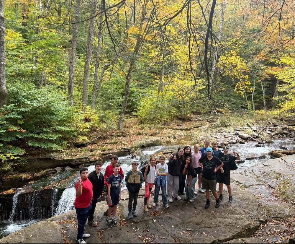 group of students by a waterfall