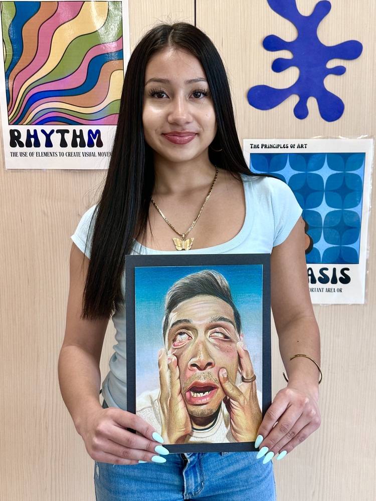 Gabriella holding up her art