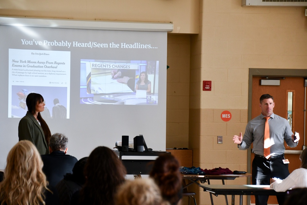 two presenters in front of a smartboard