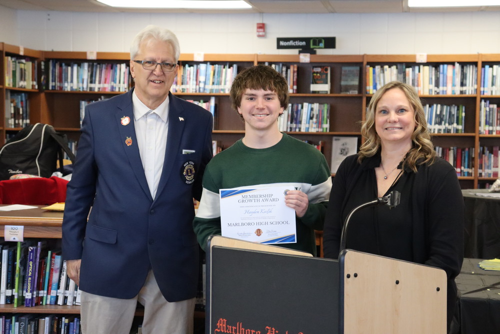A Leo Club inductee poses with an award