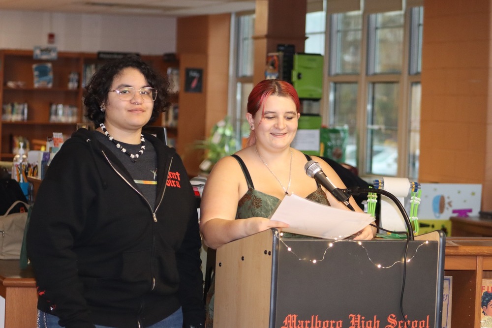 Two students standing at a lecturn