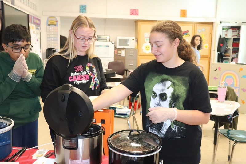 A student helps serve tacos