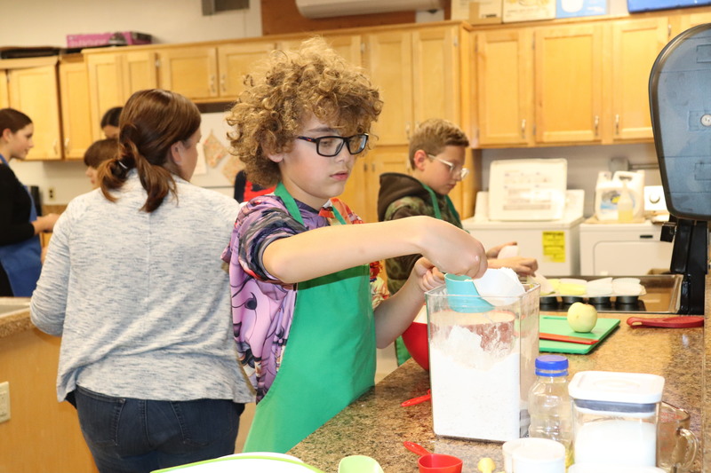 A student measures flour