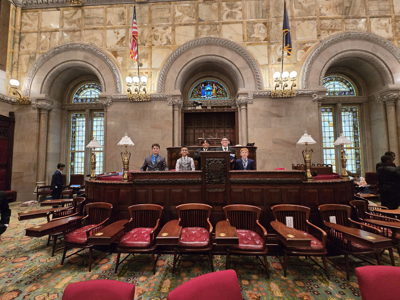 Students posing in a state government chamber