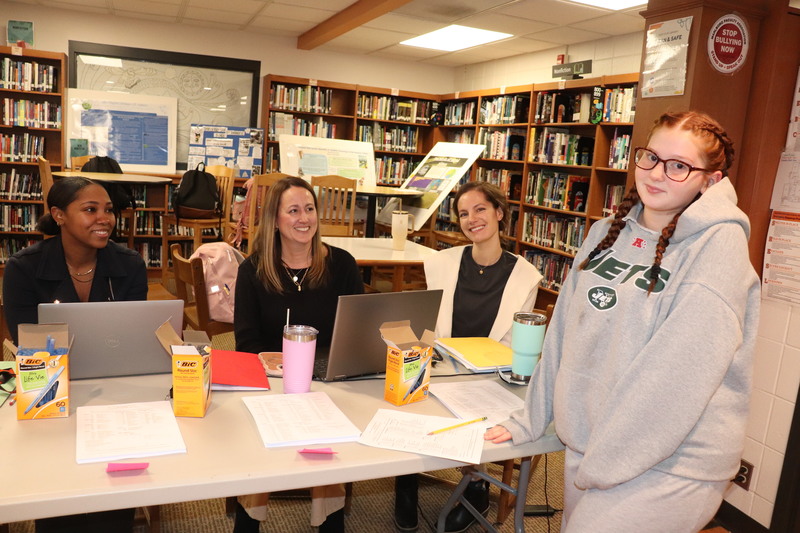 A student poses with school counselors