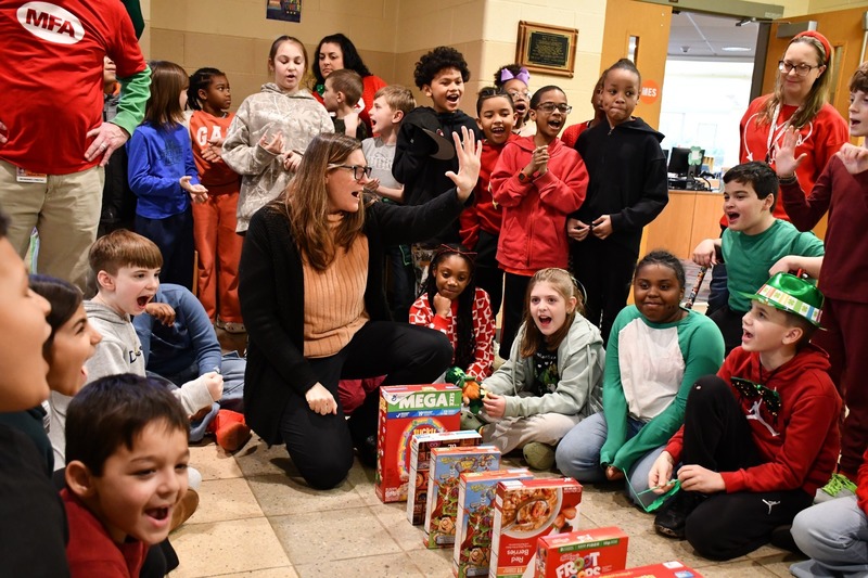 teacher counting down from five with a bunch of students cheering her on in excitment