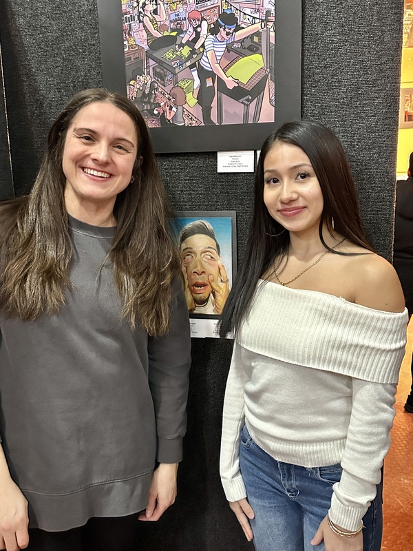 Gabriella and her teacher posing with her art