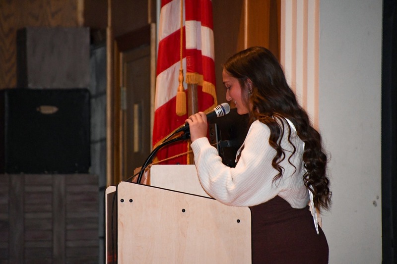 female student holding a microphone and speaking