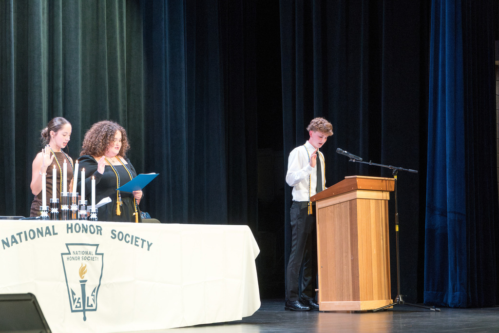 Two NHS officers stand on stage with their right hands raised, leading the NHS pledge.