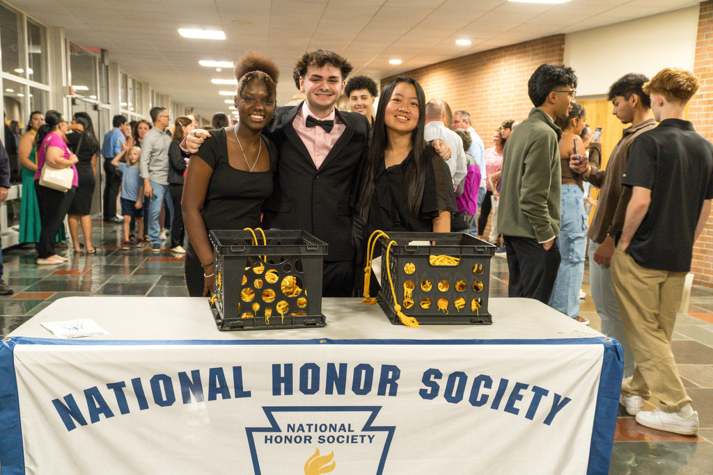 Three new NHS members pose for a group photo at the NHS table.
