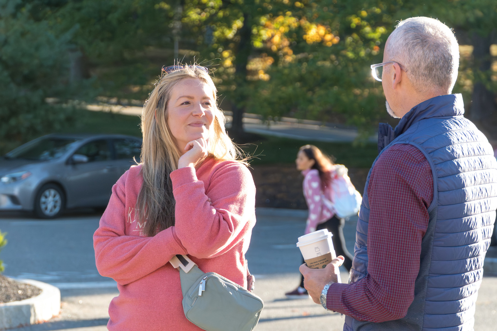 A Richer School mom smiles while talking to Interim Superintendent Jason DeFalco outside.