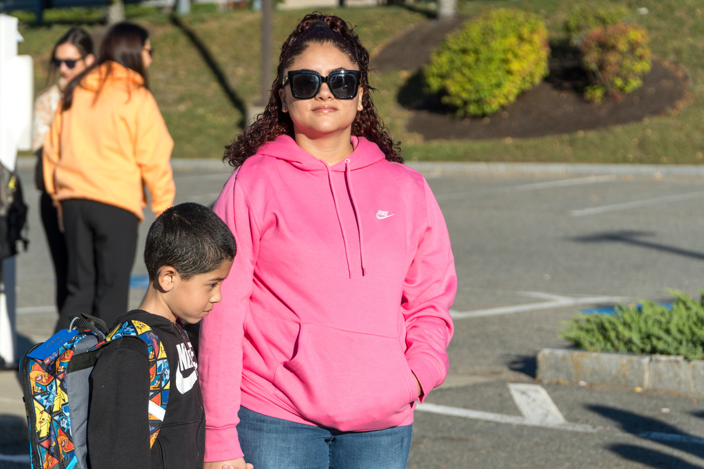 A Richer School mom stands outside with her son.