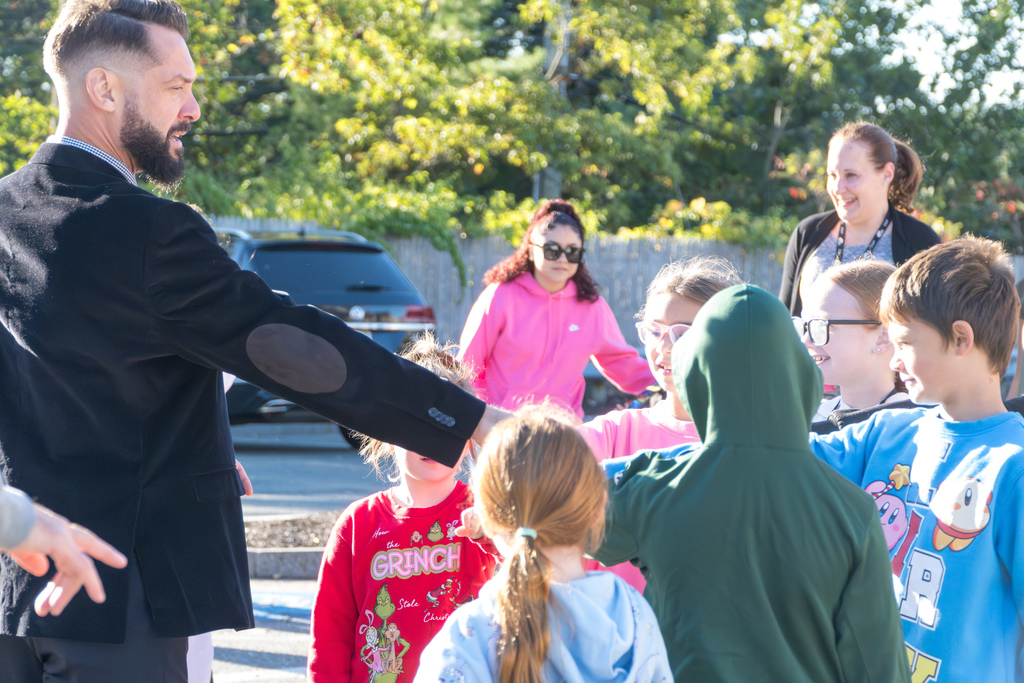 Assistant Superintendent RJ Skaza forms a huddle with Richer School students outside.