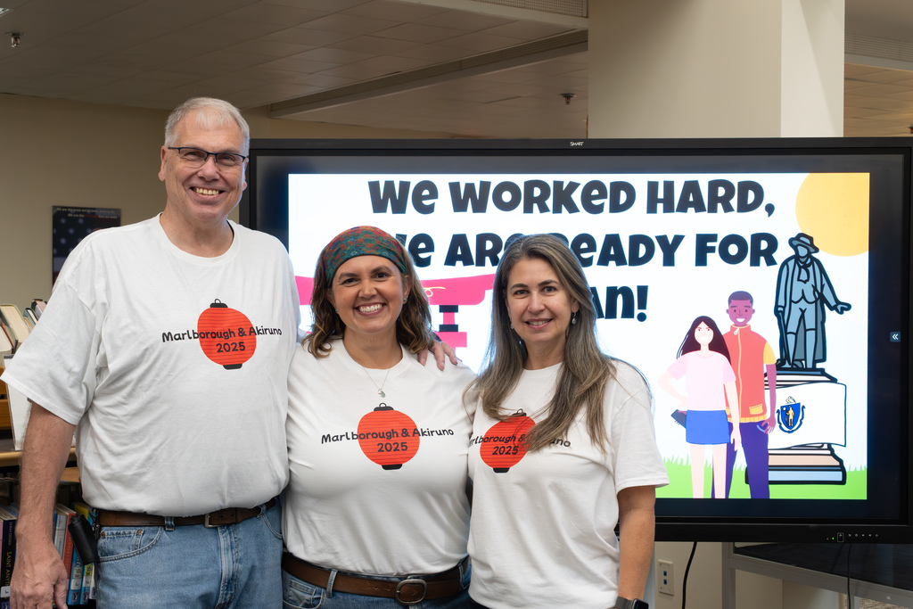 Japanese student exchange program advisors and teaching assistant Andreia Pontes pose for a group photo wearing matching shirts.