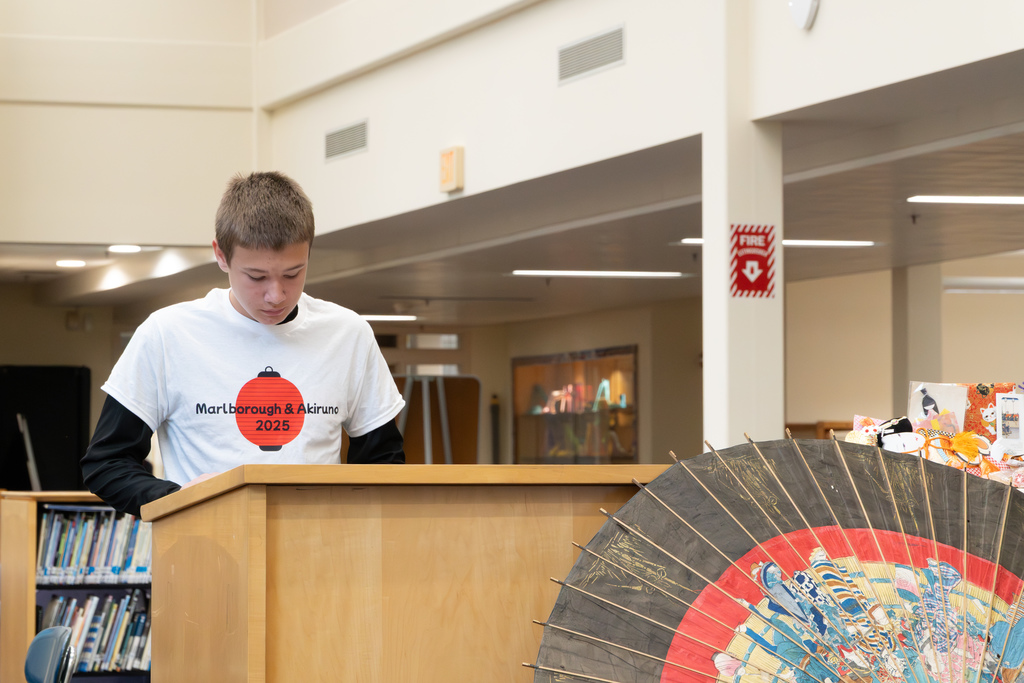 A student delegate recites his speech in Japanese at a podium.