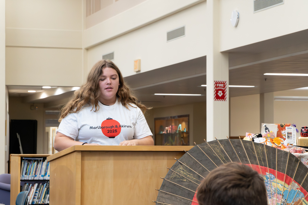 A student delegate recites her speech in Japanese at a podium.