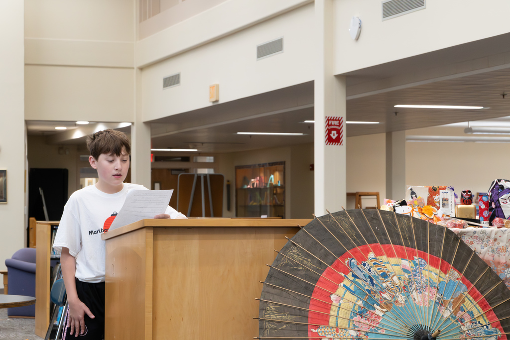 A student delegate recites his speech in Japanese at a podium.