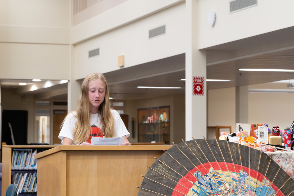 A student delegate recites her speech in Japanese at a podium.