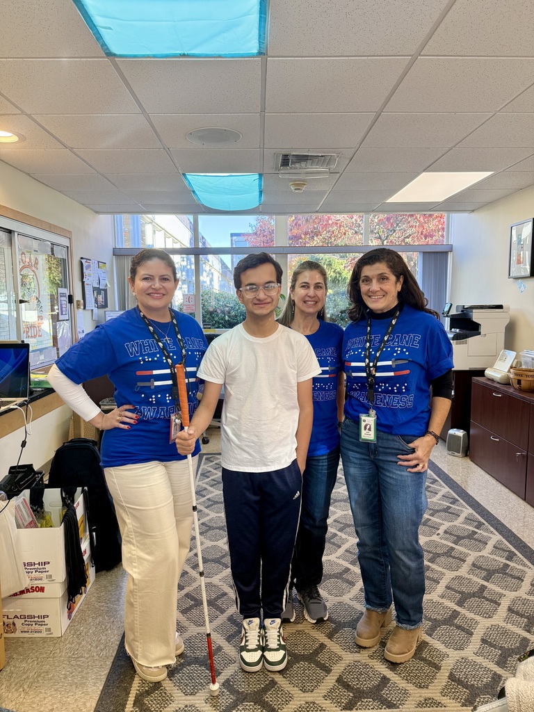 Three MPS staff members pose for a group photo with a visually impaired student who uses a white cane.