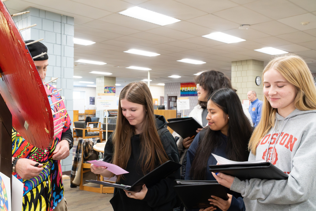 Three students review their budget at the Wheel of Fortune or Misfortune during the 2025 MHS Reality Fair.