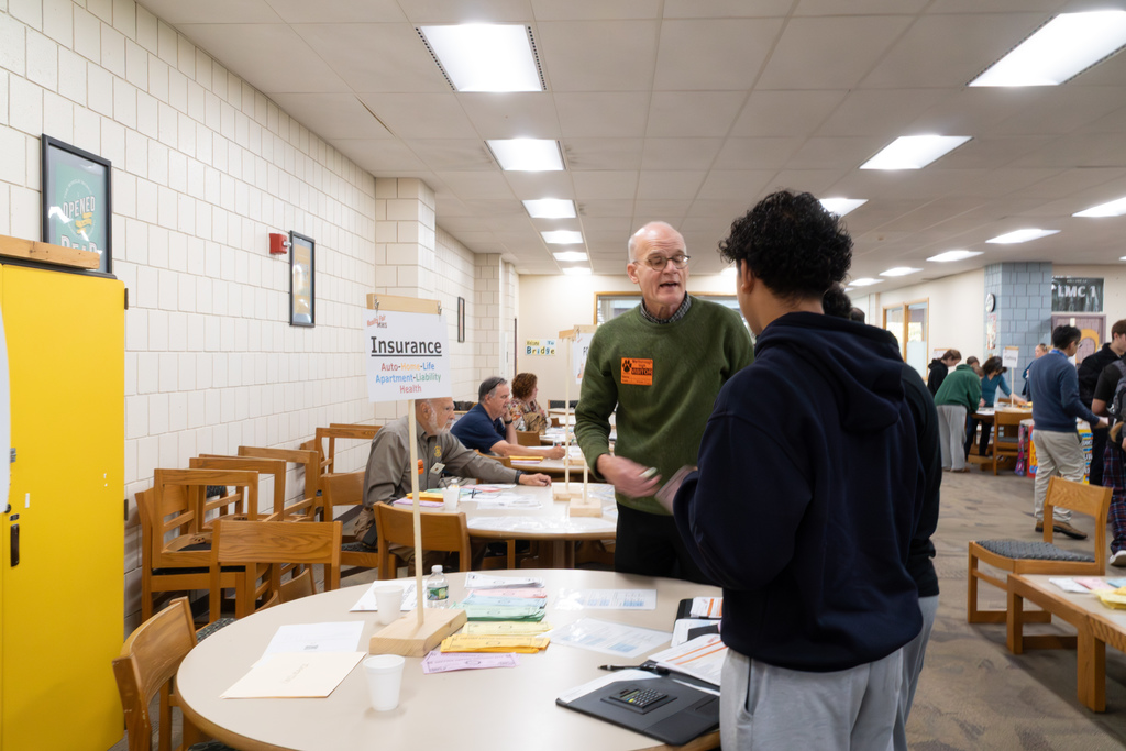A volunteer insurance agent helps students during the 2025 Reality Fair at MHS.