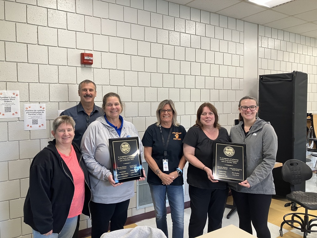  Six MPS nutrition services staff members pose with two plaques.