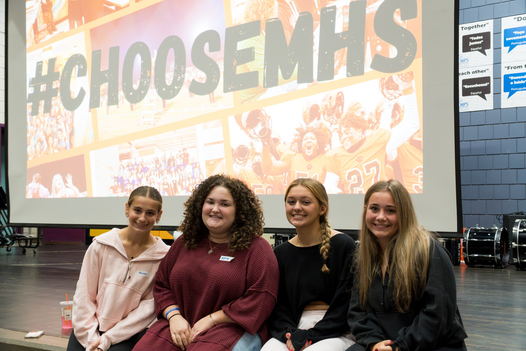 Four Marlborough High School students sit in front of a screen that reads "Choose MHS."