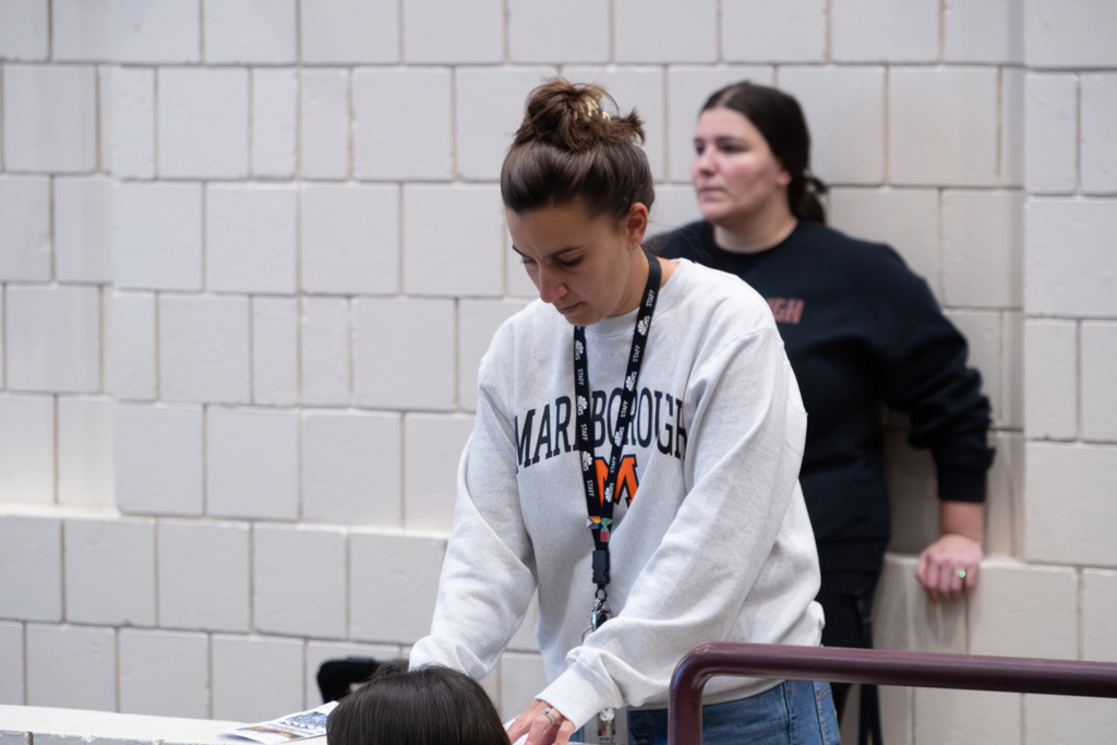 Whitcomb School Principal Angela House, wearing a Marlborough sweatshirt, folds brochures.