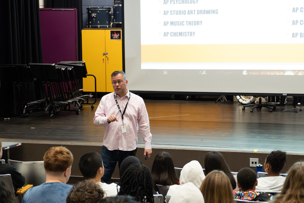 MHS Principal Stephen Sierpina speaks to 8th-grade students in an auditorium.
