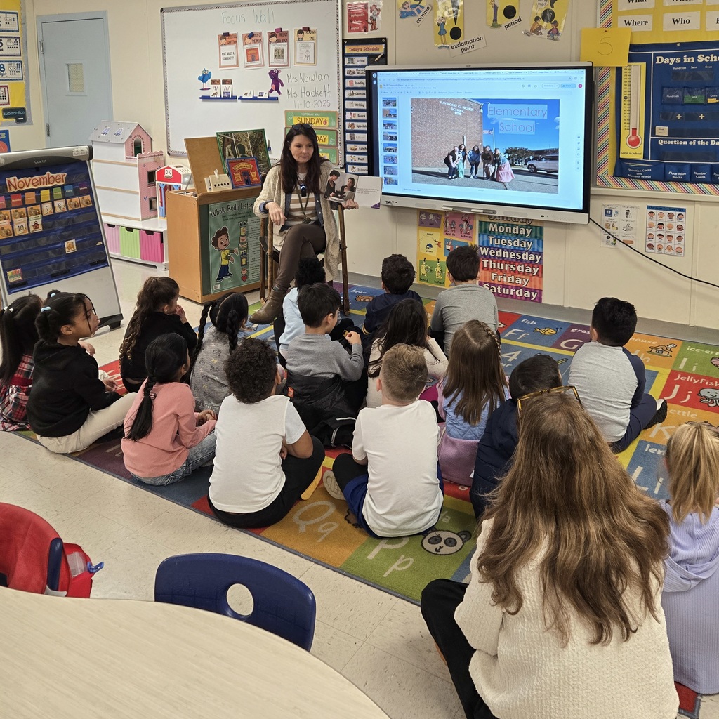 Richer School Principal Lisa Richards sits and reads to a group of students.
