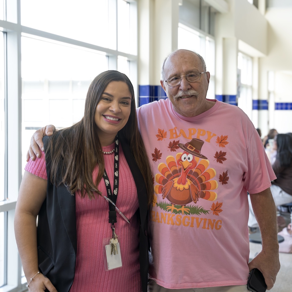 MPS RPOC manager Daisy Reis and Whitcomb custodian Gary pose for a photo. Gary wears a pink shirt with a turkey and the words "Happy Thanksgiving."