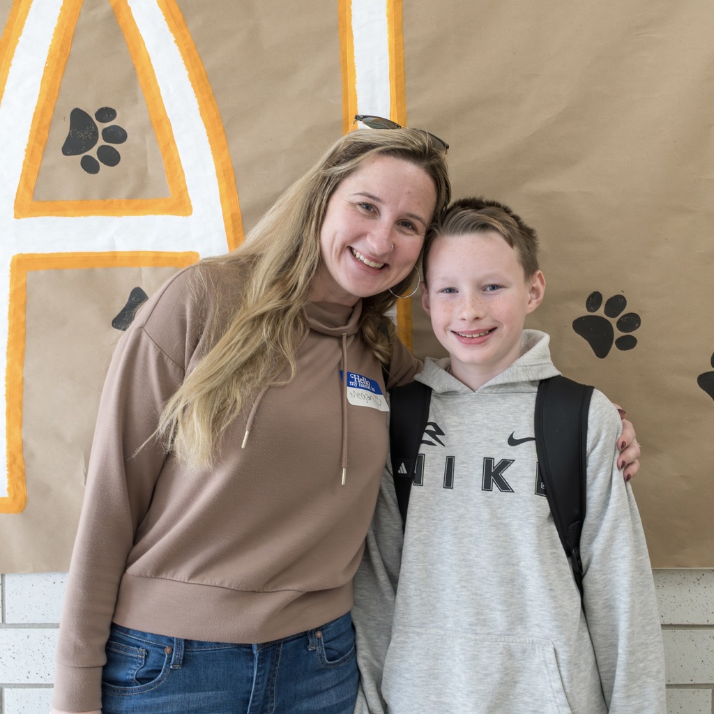 A Whitcomb parent and student smile and pose for a group photo.
