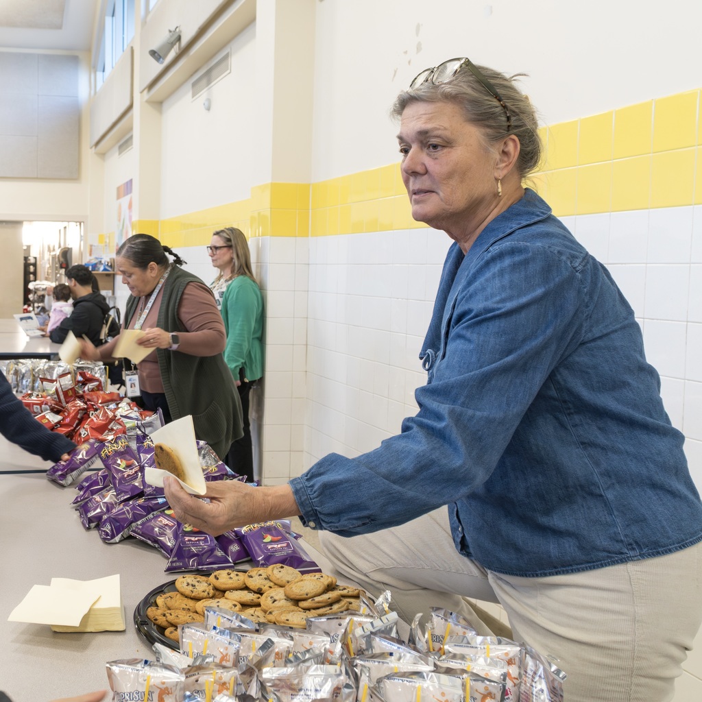 A Whitcomb staff member hands out cookies in the cafeteria.